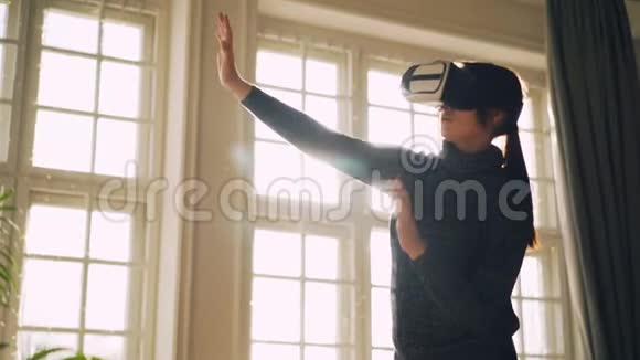 年轻的女士在虚拟现实眼镜中享受着新的体验戴着ar的手臂和身体站在房间里视频的预览图