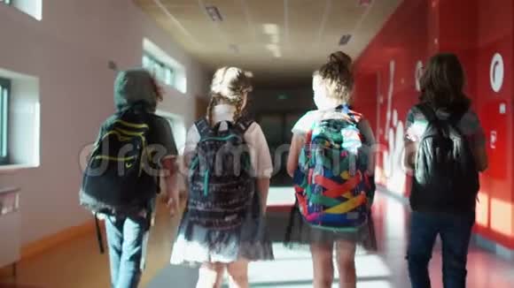 回学校去后景学生穿过学校走廊两个男孩和两个女孩孩子们背背包视频的预览图
