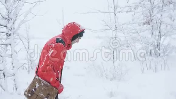 在白雪覆盖的森林里行走的男性旅行者视频的预览图