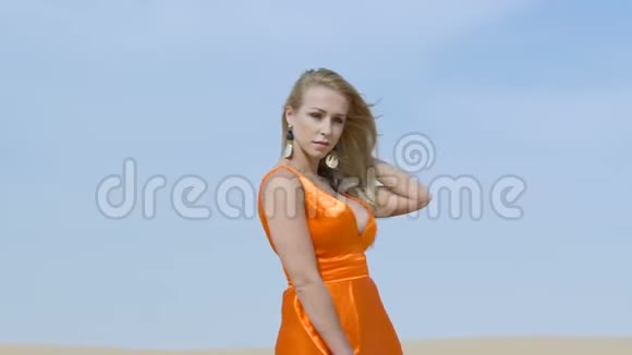 女孩散步在巴克汉的沙漠中玩得开心女人微笑着拂过头发在炎热的沙漠下的沙丘上行走视频的预览图