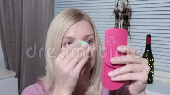 年轻女子照镜子在家化妆视频的预览图