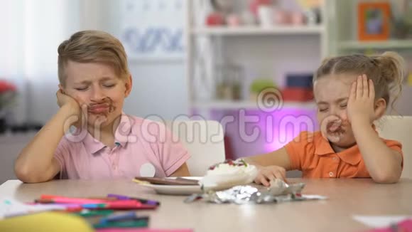两个孩子在桌上抹了巧克力胃痛暴饮暴食视频的预览图