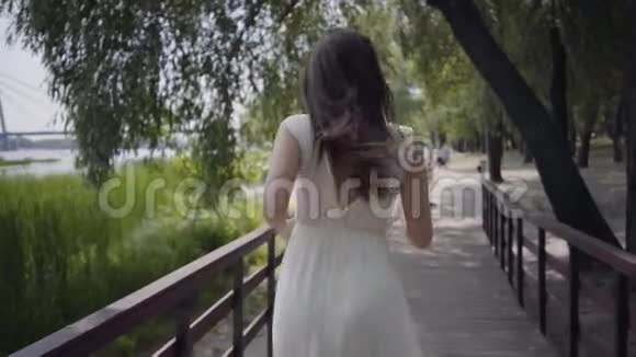 肖像可爱的年轻女孩一头黑发戴着太阳镜穿着白色的夏装穿着一件白色的长裙视频的预览图