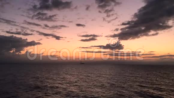 日落黄昏的天空在海面上的鸟瞰太阳沿着地平线下降天空中有戏剧性的云彩在4k视频的预览图