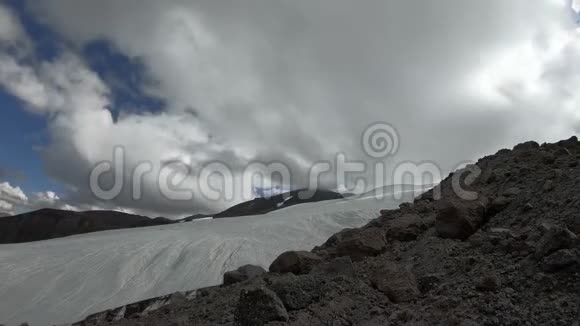 冰川和山谷的一部分有多岩石的山脉云浮在天空中它们视频的预览图