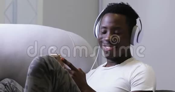 非洲男人在家听耳机音乐享受声音视频的预览图