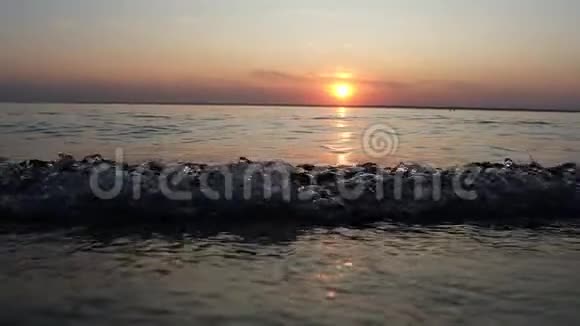 在美丽的日落背景下缓慢运动的海浪视频的预览图