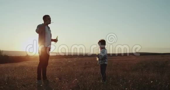 度过了一个完美的时光爸爸和儿子在大自然惊人的日落制造泡泡视频的预览图