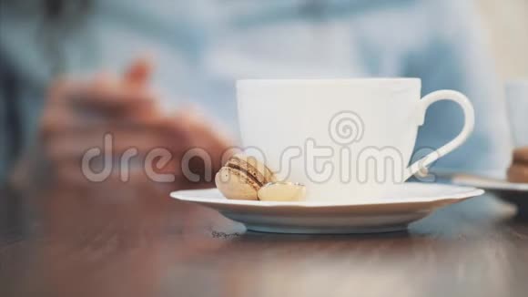 在咖啡馆的桌子上放着一大杯卡布奇诺在这个女孩里喝了一口卡布奇诺在上面放了一个杯子视频的预览图
