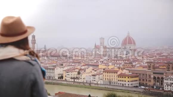 快乐的年轻女性旅行者走上前去在智能手机上拍摄意大利佛罗伦萨秋天令人惊叹的城市景观全景视频的预览图