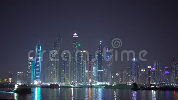 迪拜在晚上准备2020年世博会建筑建设船沿JBR码头游泳从海上或棕榈岛观看视频的预览图