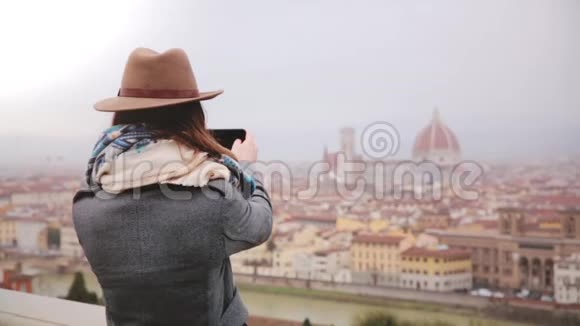 快乐的旅游女孩拍摄智能手机照片令人惊奇的全景冬季多雨佛罗伦萨意大利步行离开视频的预览图