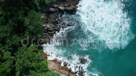 从空中俯瞰海洋美丽的波浪和充满绿色的岩石海岸视频的预览图