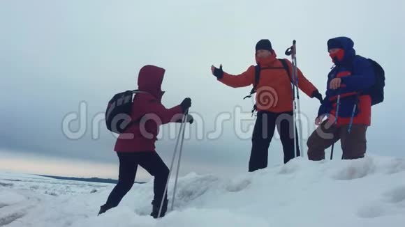 攀爬帮助队友攀爬拿着背包的人伸出一只帮助他的朋友的手三个登山者视频的预览图