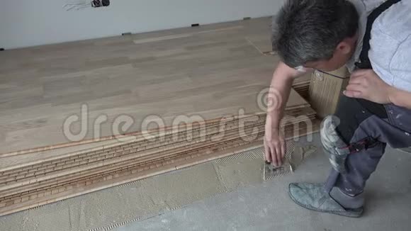 用抹刀将木胶粘在混凝土地板上视频的预览图