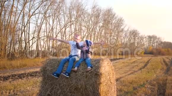 孩子们坐在干草堆上他们玩和笑乡村日落视频的预览图