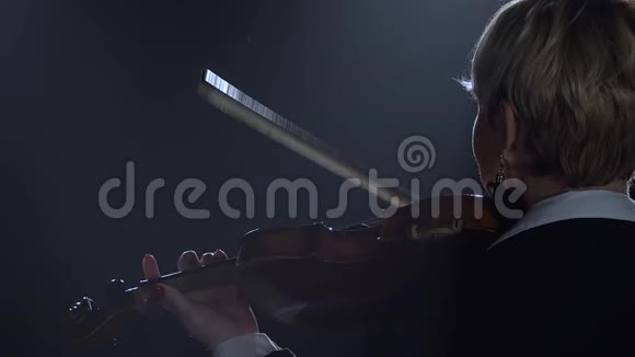 女孩背对着镜头拉小提琴黑烟背景视频的预览图