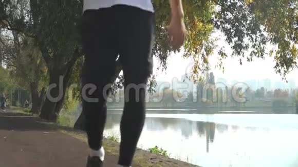 一个年轻人跑在公园里停下来喝瓶子里的水视频的预览图
