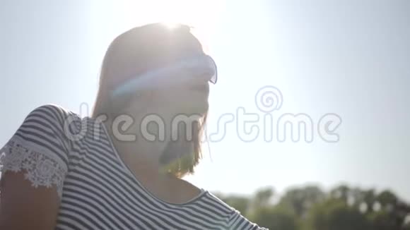 可爱的红发女人戴着太阳镜笑容满面阳光在水中闪烁视频的预览图