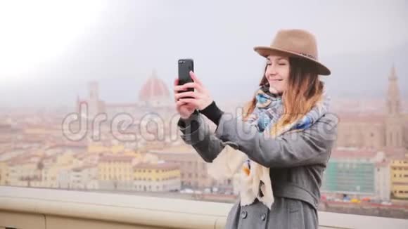 快乐女游客在令人难以置信的意大利秋季佛罗伦萨全景拍摄智能手机自拍照片欣赏风景视频的预览图