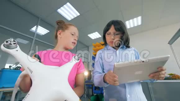 一个女孩和一个男孩在实验室工作修理无人机无人机视频的预览图