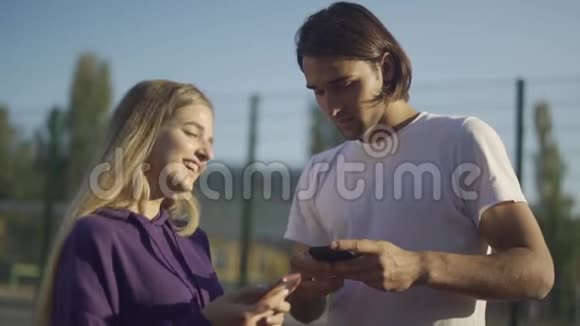 男人和女人用手中的电话互相交流视频的预览图