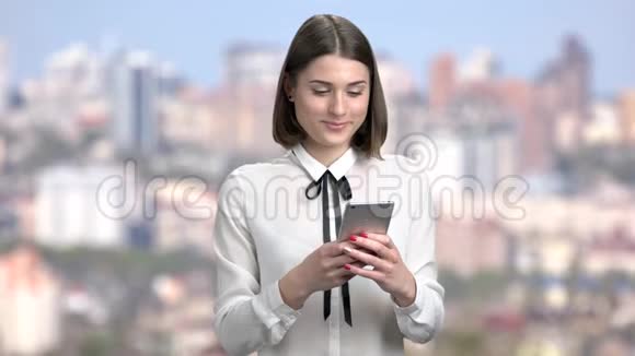 漂亮的商务女性在智能手机上写信息视频的预览图