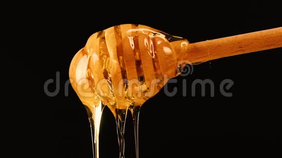 把蜂蜜从黑色的木嘴里流出来视频的预览图