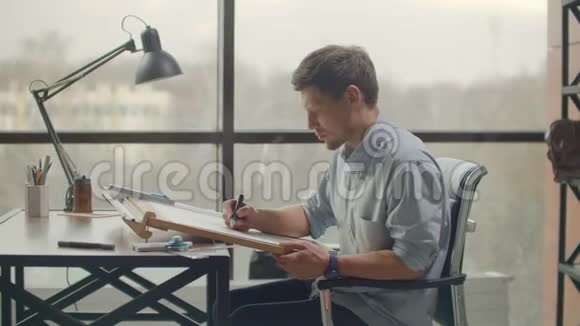 白天建筑师坐在现代工业办公室的写字台旁视频的预览图