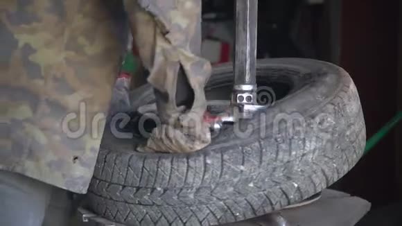 汽车机械师在车轮上装配轮胎冬季轮胎视频的预览图