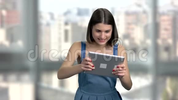 迷人的女人在电脑平板电脑上玩视频的预览图