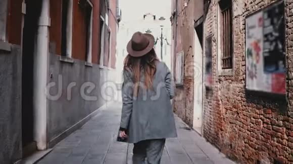 相机跟随迷人的专业女记者相机沿着意大利威尼斯美丽的街道行走视频的预览图