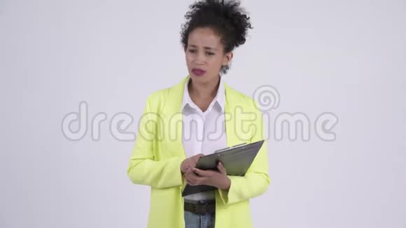 年轻愤怒的非洲女商人一边拿着夹子一边说话视频的预览图