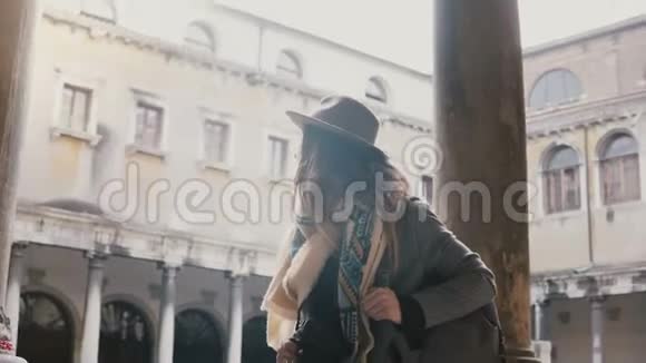 快乐的职业女性博客作者带着相机拍照在意大利威尼斯的古老建筑上漫步视频的预览图