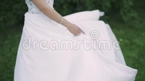 新娘在公园里穿着夏日晚礼服旋转视频的预览图