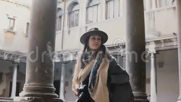 美丽的女游客带着相机行走看着威尼斯古色古香的建筑露台视频的预览图