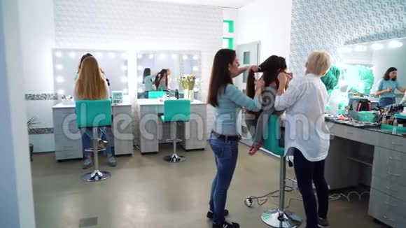 美容美发团队为可爱可爱的年轻女性化妆和发型视频的预览图