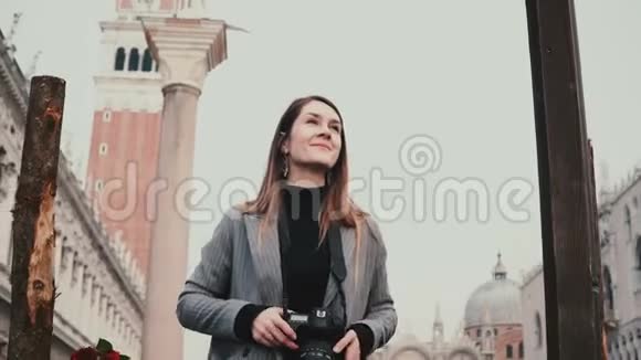 颇具吸引力的职业白人记者用相机拍摄意大利威尼斯老城的古建筑视频的预览图