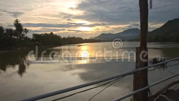 日落时从桥上看到宁静的河流和木本河岸视频的预览图