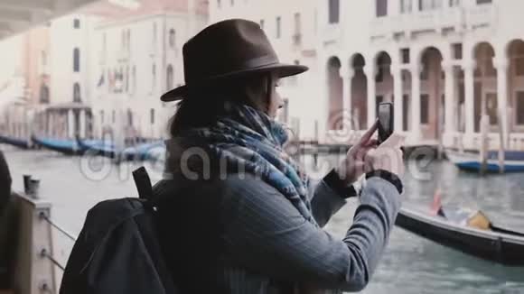快乐美丽的欧洲女性游客在一次沿着威尼斯运河的贡多拉游旅上拍摄智能手机照片视频的预览图