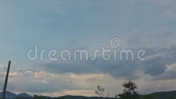多云的天空笼罩着树木丘陵乡村土地视频的预览图