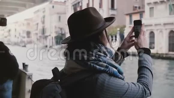 快乐迷人的高加索女商人在威尼斯度假期间的一次贡多拉游旅上拍摄智能手机照片视频的预览图