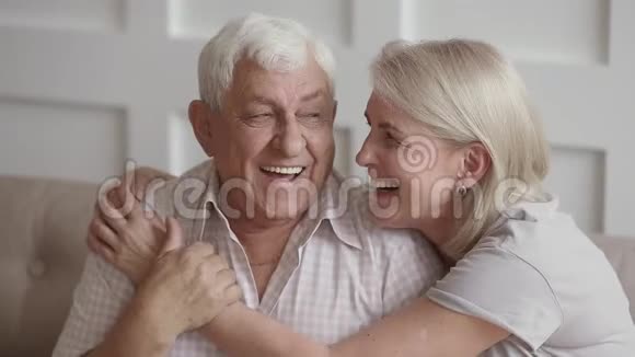 幸福深情的老两口拥抱在一起看着镜头视频的预览图