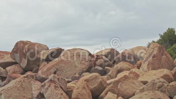 山脚海滩上的大型岩石堆上的盖伊堆视频的预览图