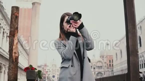 美丽的女性专业摄影师带着相机在意大利威尼斯老城的木制柱子附近拍照视频的预览图