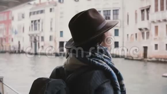 美丽放松的欧洲旅游女孩看着相机微笑着在秋天的威尼斯奇妙的贡多拉游览视频的预览图
