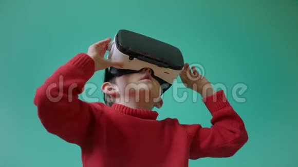 兴奋的小男孩使用虚拟现实耳机体验虚拟现实视频的预览图