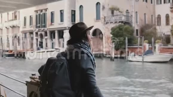 快乐微笑的白种人旅游女孩拍照在贡多拉游览威尼斯运河期间打电话视频的预览图