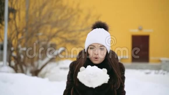 一个穿貂皮大衣的女孩用手套吹雪视频的预览图