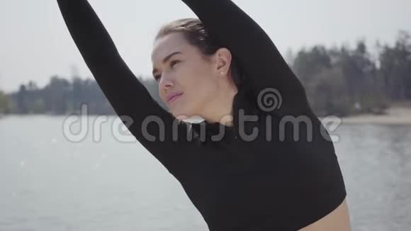 肖像可爱的运动迷人的苗条年轻女子做运动锻炼站在河岸上美丽的风景视频的预览图